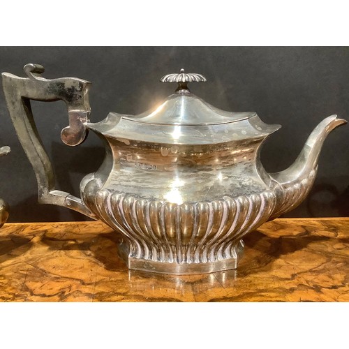 776 - An Edwardian silver half fluted three piece tea service, comprising teapot, sugar basin and cream ju... 