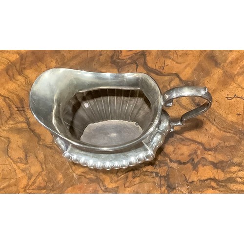 776 - An Edwardian silver half fluted three piece tea service, comprising teapot, sugar basin and cream ju... 