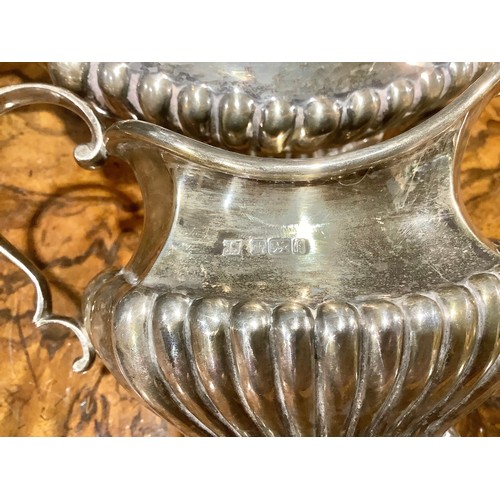 776 - An Edwardian silver half fluted three piece tea service, comprising teapot, sugar basin and cream ju... 