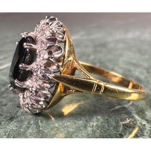 925 - An 18ct gold, diamond and sapphire oval cluster ring, the central stone claw set above a ring of old... 