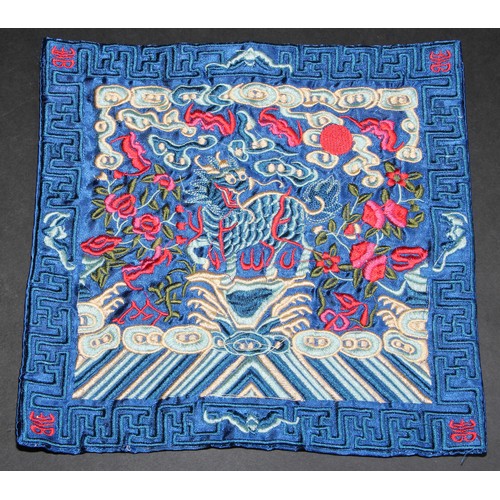 447 - A Chinese silk rank badge or Mandarin square, worked in coloured threads with a dragon, 26cm square;... 