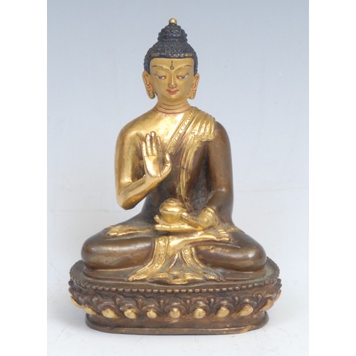 2087 - Chinese/Tibetan School, a gilt and patinated bronze, Buddha, seated in a lotus, holding a bowl, pain... 