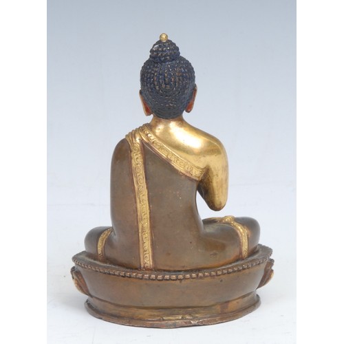 2087 - Chinese/Tibetan School, a gilt and patinated bronze, Buddha, seated in a lotus, holding a bowl, pain... 