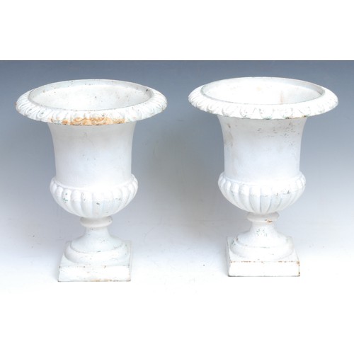 2137 - A pair of cast iron half-fluted campana shaped urns, egg-and-dart borders, square bases, 27.5cm high