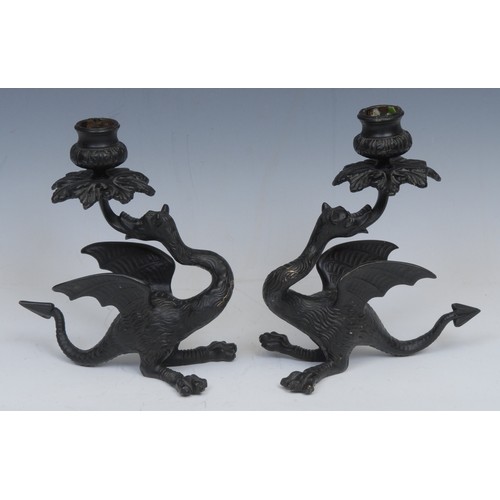 2139 - A pair of Continental dark patinated bronze candlesticks, cast as wyverns, 19.5cm high