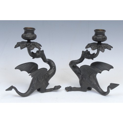 2139 - A pair of Continental dark patinated bronze candlesticks, cast as wyverns, 19.5cm high