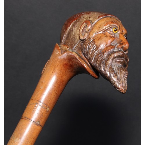 2213 - A 19th century walking stick or cane, the pommel carved as the head of a bearded man, wearing a fez,... 