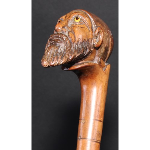 2213 - A 19th century walking stick or cane, the pommel carved as the head of a bearded man, wearing a fez,... 