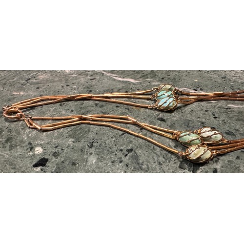 916 - A turquoise and yellow metal articulated tube link necklace, each of the three strands evenly divide... 