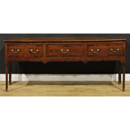 1305 - A George III mahogany crossbanded oak low dresser, slightly oversailing top above three frieze drawe... 