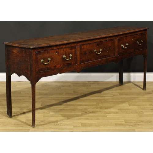 1305 - A George III mahogany crossbanded oak low dresser, slightly oversailing top above three frieze drawe... 