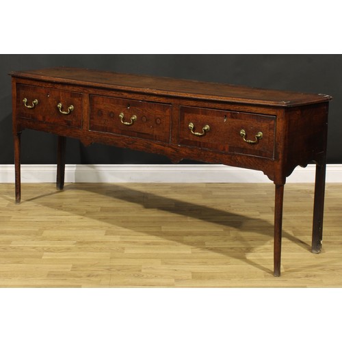 1305 - A George III mahogany crossbanded oak low dresser, slightly oversailing top above three frieze drawe... 