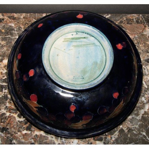 7 - A Moorcroft Pomegranate pattern circular bowl, tube lined with large fruit and berries, on a mottled... 