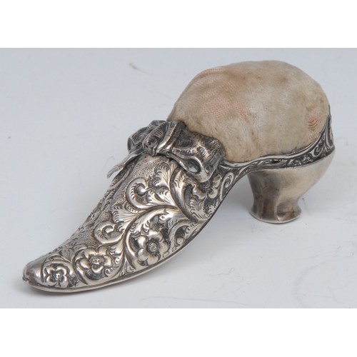 792 - An Edwardian silver novelty pin cushion, as a shoe, chased with scrolling foliage, 9cm long, Birming... 