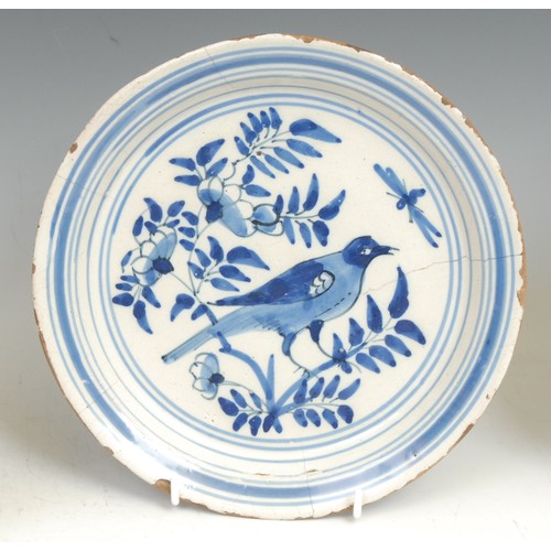 109 - An 18th century Delft circular plate, painted in the chinoiserie taste with a figure in a Chinese ga... 