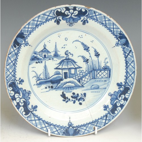 109 - An 18th century Delft circular plate, painted in the chinoiserie taste with a figure in a Chinese ga... 