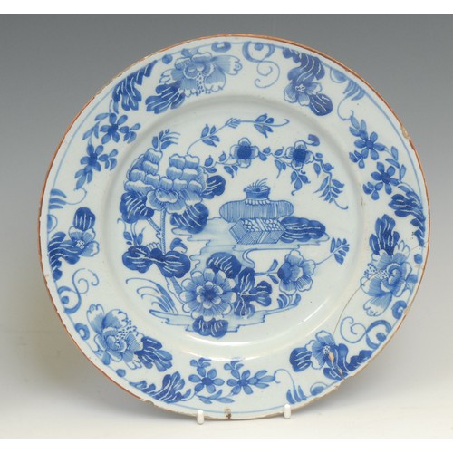 108 - An 18th century Delft circular plate, painted in the Chinese taste with precious objects and chrysan... 