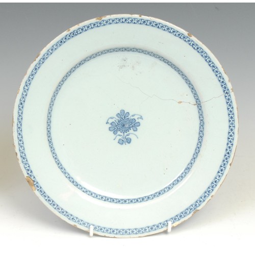 105 - An 18th century Delft circular dish, painted in tones of blue in the Chinese taste with a flowering ... 