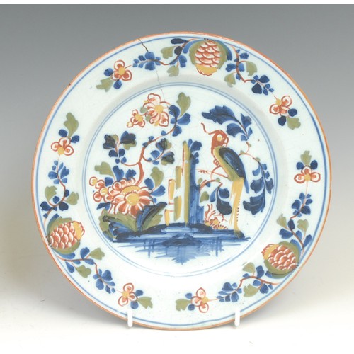 107 - An 18th century Delft circular plate, painted in the Chinese taste with a lady in a garden, 21.5cm d... 