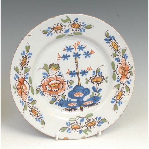 107 - An 18th century Delft circular plate, painted in the Chinese taste with a lady in a garden, 21.5cm d... 