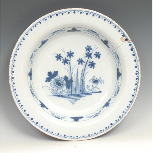 97 - A large 18th century Delft circular charger, painted in the Chinese taste with a pine tree and chrys... 