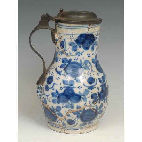 111 - An 18th century Delft night light, moulded with masks and painted in tones of blue with leaves and f... 