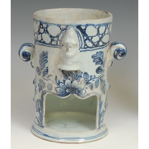 111 - An 18th century Delft night light, moulded with masks and painted in tones of blue with leaves and f... 