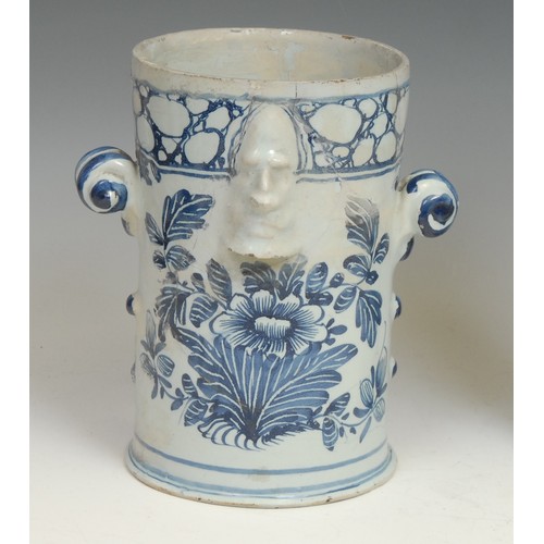 111 - An 18th century Delft night light, moulded with masks and painted in tones of blue with leaves and f... 