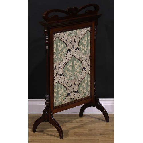 1556 - An Art Nouveau mahogany fire screen, shaped cresting pierced with stylised flowers on whiplash stems... 