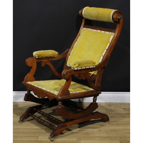 1566 - An unusual 19th century American walnut rocking chair, adjustable headrest, shaped arms, reeded bord... 