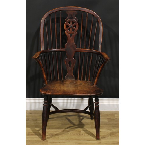 A 19th century yew and elm wheelback Windsor elbow chair, saddle seat ...