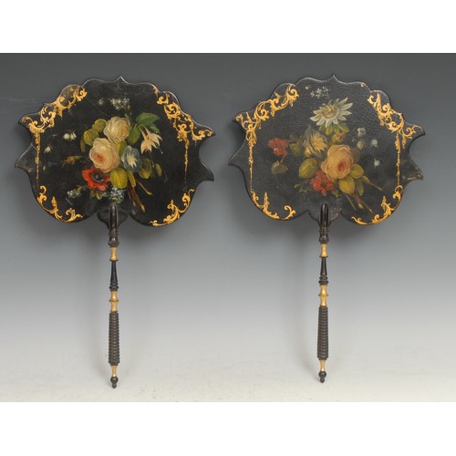 2180 - A pair of Victorian papier mache hand face screens, each painted with flowers on a japanned ground, ... 