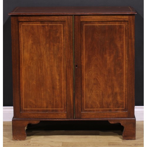 1245 - A 19th century mahogany enclosed bookcase, oversailing top above a pair of panel doors enclosing adj... 