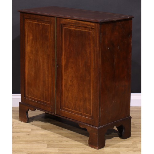 1245 - A 19th century mahogany enclosed bookcase, oversailing top above a pair of panel doors enclosing adj... 