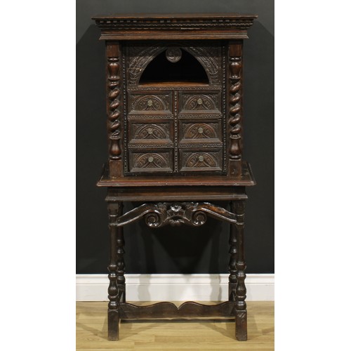 1293 - A 19th century Continental oak collector’s cabinet on stand, dentil cornice above an arched niche an... 