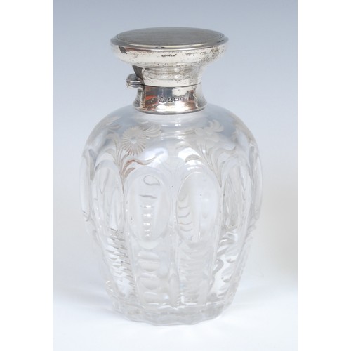 612 - A George V silver mounted ovoid secent bottle, hinged cover engine turned in bands, enclosing a stop... 