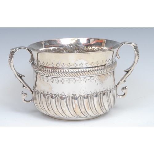 641 - A large Victorian Irish silver porringer, half-fluted chased and punched, and centred by an oval vac... 