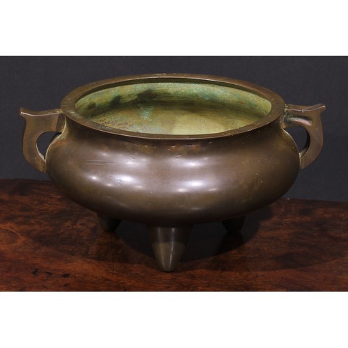 435 - A Chinese bronze tripod ding censer, scroll handles, 22cm wide, 19th century