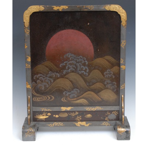 369 - A Japanese lacquer table screen, decorated with the sun rising behand crashing waves, gilt brass mou... 