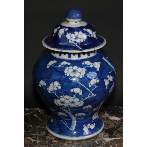 383 - A Chinese baluster ginger jar and cover, painted in tones of underglaze blue with blossoming prunus ... 