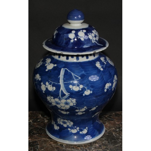 383 - A Chinese baluster ginger jar and cover, painted in tones of underglaze blue with blossoming prunus ... 