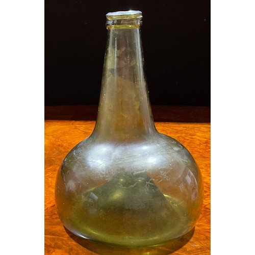 2208 - An early 18th century olive glass onion bottle, trailed rim, kick up base with pontil scar, 20cm hig... 