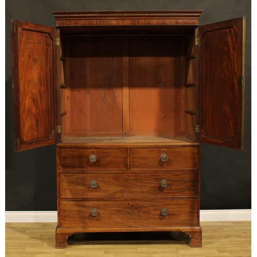 1547 - A Post-Regency mahogany hanging linen press, moulded cornice above a pair of flame-veneered panel do... 