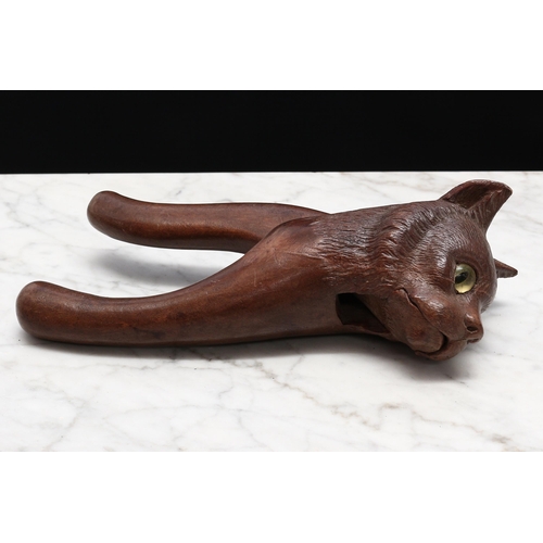 2233 - Nutcrackers - a Black Forest novelty lever-action nut cracker, carved as the head of a cat, glass ey... 