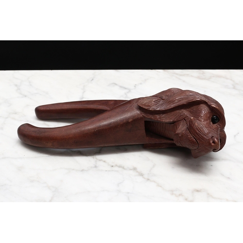 2234 - Nutcrackers - a Black Forest novelty lever-action nut cracker, carved as the head of a dog, glass ey... 