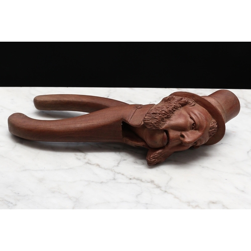 2269 - Nutcrackers - a Black Forest novelty lever-action nut cracker, carved as the head of a bearded gentl... 