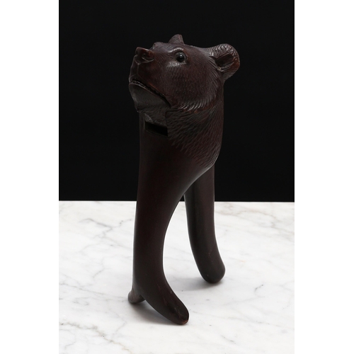 2266 - Nutcrackers - a Black Forest novelty lever-action nut cracker, carved as the head of a bear, glass e... 