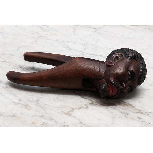 2262 - Nutcrackers - a Black Forest novelty lever-action nut cracker, carved and polychrome painted as a ge... 