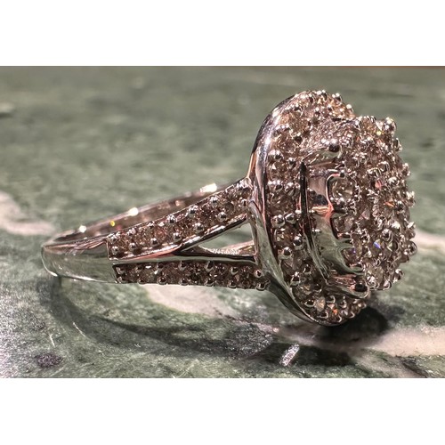 870 - A contemporary diamond cluster ring, multi level target crest set with forty eight round brilliant c... 