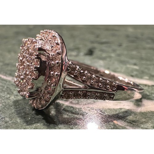 870 - A contemporary diamond cluster ring, multi level target crest set with forty eight round brilliant c... 